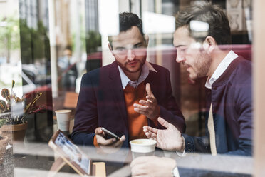 USA, New York City, Geschäftsleute treffen sich in einem Café und benutzen mobile Geräte - UUF09233