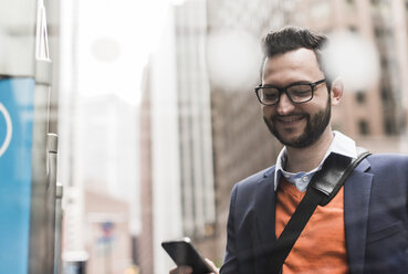 USA, New York City, Businessman using smart phone - UUF09235