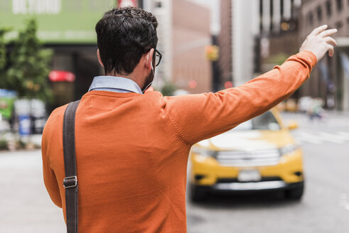 USA, New York City, Geschäftsmann hält Taxi an - UUF09240