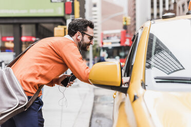 USA, New York City, Geschäftsmann im Gespräch mit Taxifahrer - UUF09245