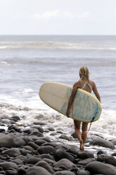 Indonesien, Bali, Frau mit Surfbrett auf dem Meer - KNTF00582