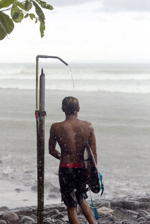 Indonesien, Bali, Surfer beim Duschen im Regen - KNTF00583