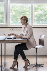 Geschäftsfrau mit Laptop in einem modernen Konferenzraum - RIBF00588