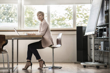 Geschäftsfrau mit Laptop in einem modernen Konferenzraum - RIBF00589