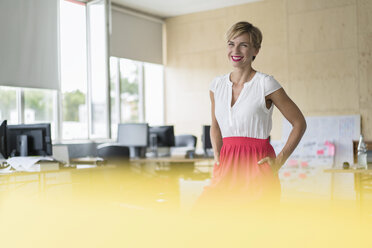 Smiling woman standing in creative office - RIBF00636