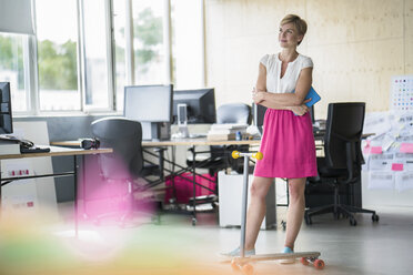 Woman standing in creative office - RIBF00649