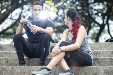 Friends taking a break in fitness park, sitting on stairs - ZEF11663