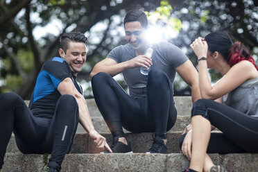 Freunde machen eine Pause im Fitnesspark, sitzen auf einer Treppe - ZEF11664