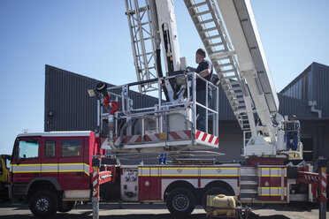 Mechaniker, die ein Feuerwehrauto warten - ZEF11699