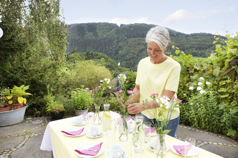 Ältere Frau Dekoration Garten Tisch für Geburtstagsfeier, lizenzfreies Stockfoto