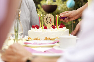 Hand lighting candles on 80th birtday cake - MFRF00767