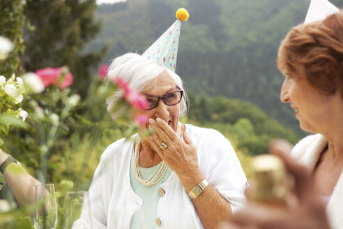 Ältere Damen lachen beim Feiern, tragen Partyhüte - MFRF00778