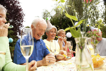 Seniors celebrating birthday oarty in garden - MFRF00792