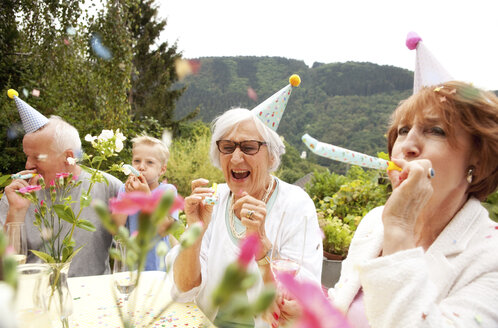 Seniors celebrating birthday oarty in garden - MFRF00793