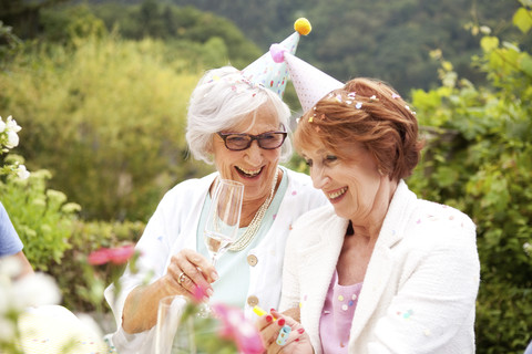 Ältere Damen trinken Champagner auf einer Geburtstagsfeier, lizenzfreies Stockfoto