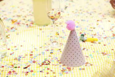 Partyhut und Partybläser auf Tisch mit Konfetti - MFRF00813
