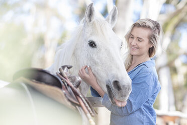 Lächelnde Frau mit Pferd auf einem Pferdehof - ZEF11744