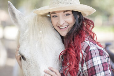 Porträt einer lächelnden jungen Frau mit Pferd - ZEF11745