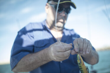 Man applying bait on fishing rod - ZEF11751