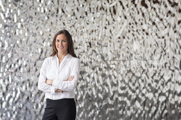 Portrait of confident businesswoman in front of rippled wall - PESF00378
