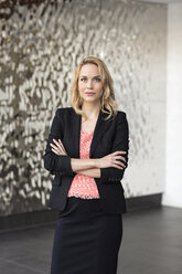 Portrait of confident businesswoman in front of rippled wall - PESF00382