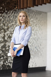 Confident businesswoman holding folder - PESF00385