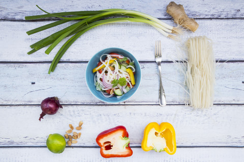 Schale mit Glasnudelsalat mit Gemüse und Zutaten auf Holz, lizenzfreies Stockfoto