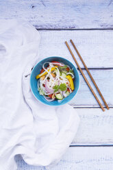 Bowl of glass noodle salad with vegetables, cloth and chopsticks on wood - LVF05612