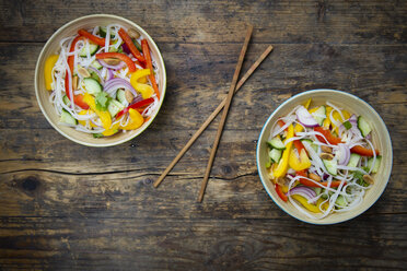Two bowls of glass noodle salad with vegetables on dark wood - LVF05621