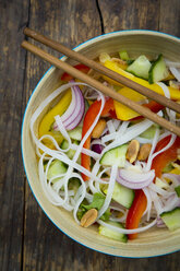 Bowl of glass noodle salad with vegetables on dark wood - LVF05622