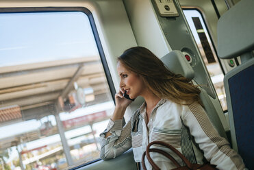 Woman on a train talking on cell phone - KIJF00866