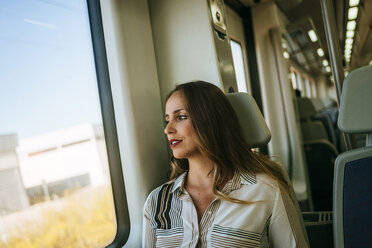 Frau in einem Zug schaut aus dem Fenster - KIJF00871