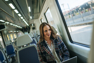 Businesswoman on a train using a laptop - KIJF00878