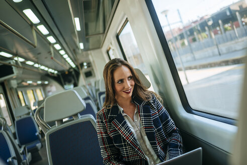 Geschäftsfrau in einem Zug mit einem Laptop - KIJF00878