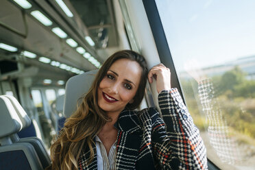 Portrait of smiling woman in a train - KIJF00890