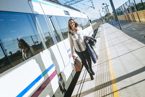 Frau geht auf dem Bahnsteig neben dem Zug - KIJF00893