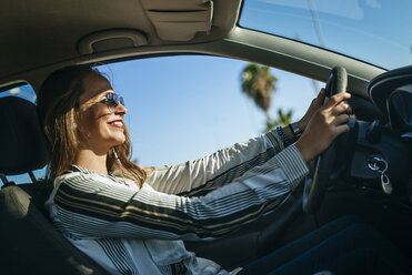 Smiling woman driving car - KIJF00904