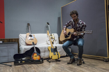 Mann spielt Gitarre in einem Aufnahmestudio - ABZF01540