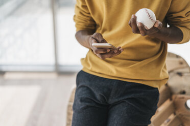 Junger Mann mit Smartphone und Baseball in der Hand - JOSF00392