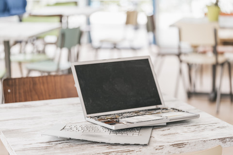 Kaputter Laptop auf dem Arbeitstisch, lizenzfreies Stockfoto