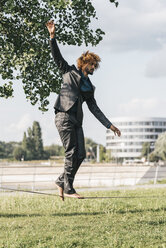 Junger Geschäftsmann balanciert auf Slackline - JOSF00425