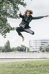 Young businessman jumping on slackline - JOSF00426