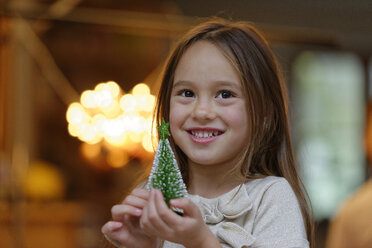 Portrait of smiling little girl with miniature Christmas tree - LBF01512