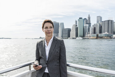 USA, Brooklyn, portrait of pensive businesswoman standing on boat - UUF09250