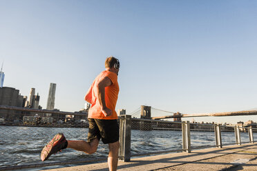 USA, Brooklyn, man jogging with headphones - UUF09306