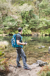 Wanderer steht am Ufer eines Flusses - RAEF01546