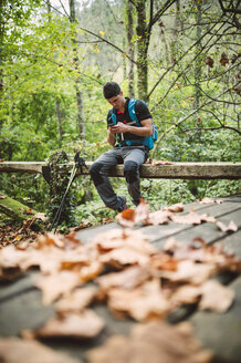 Wanderer schaut in der Natur auf sein Smartphone - RAEF01553