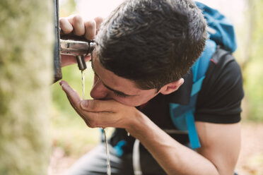 Wanderer trinkt Wasser aus einem Brunnen - RAEF01557