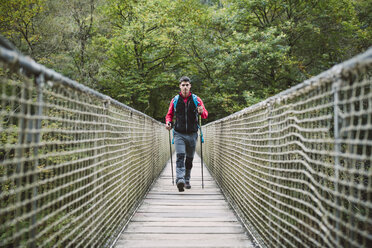 Hiker walking on a bridge in nature - RAEF01560