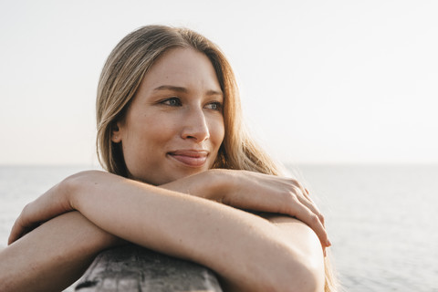 Porträt einer glücklichen jungen Frau am Meer, lizenzfreies Stockfoto